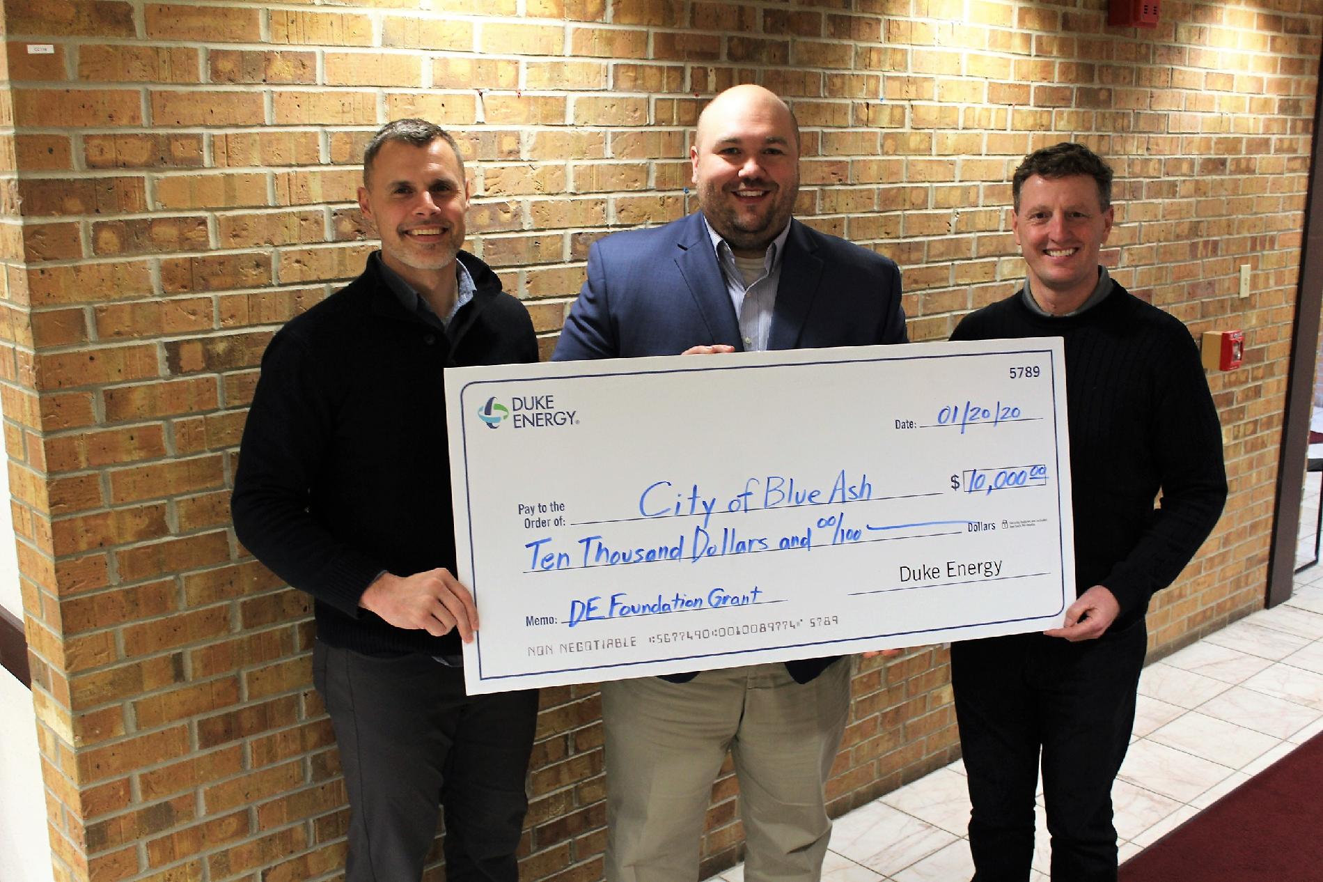 Blue Ash Parks and Recreation Director Brian Kruse, Duke Energy Sr. Government Affairs Specialist J. Chad Shaffer, and Blue Ash City Manager David Waltz hold large grant check 